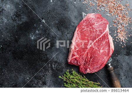 Prime Beef raw steak piece on a butchery knife. Black background. Top view. Copy space Prime Beef raw steak piece on a butchery knife. Black background. Top view. Copy space 89813464