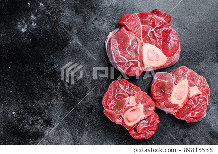 Fresh veal meat osso buco shank steak, italian ossobuco. Black background. Top view. Copy space Fresh veal meat osso buco shank steak, italian ossobuco. Black background. Top view. Copy space 89813538