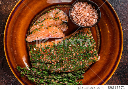 Salmon Gravlax cured with dill and pink salt on rustic plate. Dark background. Top view Salmon Gravlax cured with dill and pink salt on rustic plate. Dark background. Top view 89813571