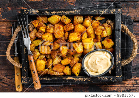 Patatas bravas traditional Spanish potatoes snack tapas. Dark wooden background. Top view Patatas bravas traditional Spanish potatoes snack tapas. Dark wooden background. Top view 89813573