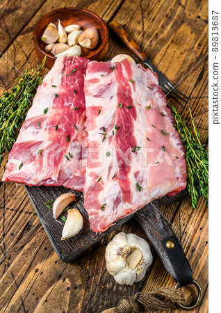 Fresh raw pork rack spareribs with thyme and garlic on cutting board. wooden background. Top view 89813687