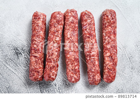Fresh raw beef meat kebabs sausages. White background. Top view 89813714