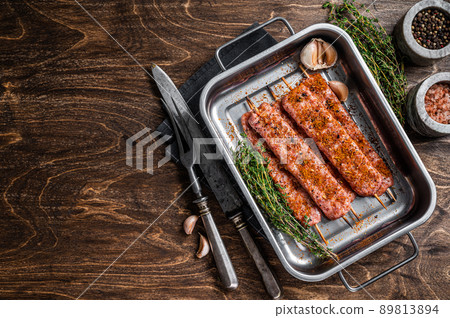 Raw Urfa shish kebab in butcher tray with herbs. Wooden background. top view. Copy space Raw Urfa shish kebab in butcher tray with herbs. Wooden background. top view. Copy space 89813894
