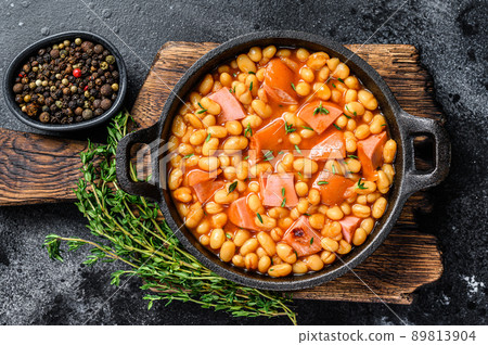 Stewed Kidney beans with smoked sausage and tomato sauce in a pan. Black background. Top view. Copy space 89813904