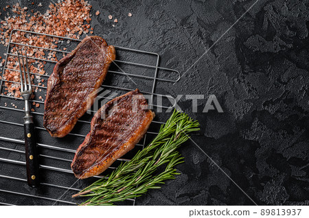 BBQ Grilled cap rump or Top sirloin beef steak, fried meat on grill. Black background. Top view. Copy space BBQ Grilled cap rump or Top sirloin beef steak, fried meat on grill. Black background. Top view. Copy space 89813937