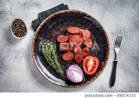 Fried sausage sucuk from beef meat on a plate with herbs. White background. Top view Fried sausage sucuk from beef meat on a plate with herbs. White background. Top view 89814155