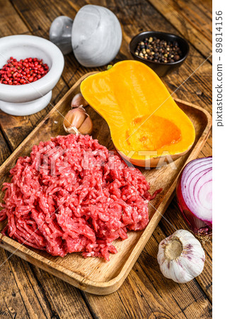 Cooking pumpkin with mince meat, garlic and onion. Wooden background. Top view Cooking pumpkin with mince meat, garlic and onion. Wooden background. Top view 89814156