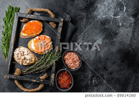 Sandwiches with Hot Smoked salmon and red caviar, toast bread with cream cheese. Black background. Top view. Copy space Sandwiches with Hot Smoked salmon and red caviar, toast bread with cream cheese. Black background. Top view. Copy space 89814160