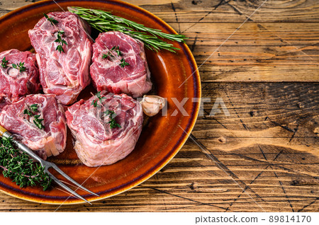 Mutton lamb neck meat on a rustic plate with thyme and rosemary. wooden background. Top view. Copy space 89814170