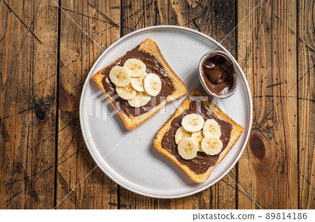 Cooking of sandwich with chocolate Hazelnut butter and bananas. Wooden background. Top view 89814186