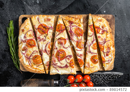 Homemade Flammkuchen or tarte flambee with cream cheese, bacon, tomato and onions. Black background. Top view Homemade Flammkuchen or tarte flambee with cream cheese, bacon, tomato and onions. Black background. Top view 89814572