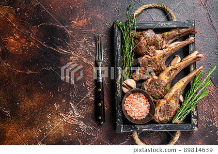 Grilled lamb chops steaks in a wooden tray. Dark background. Top view. Copy space Grilled lamb chops steaks in a wooden tray. Dark background. Top view. Copy space 89814639