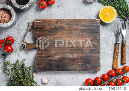 Food cooking and healthy eating background with wooden cutting board and fresh seasoning, herbs and vegetables. Gray background. Top view. Copy space Food cooking and healthy eating background with wooden cutting board and fresh seasoning, herbs and vegetables. Gray background. Top view. Copy space 89814648