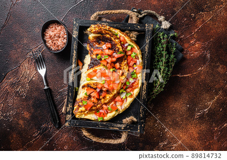 Scrambled eggs omelette with tomatoes, red bell pepper and onion. Dark background. Top view 89814732