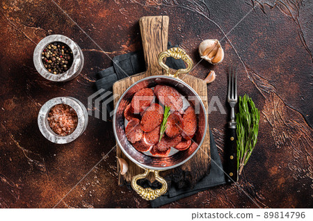Turkish fried sausage sucuk in a pan. Dark background. Top view 89814796