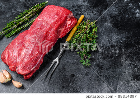 Raw fillet Tenderloin beef meat for steaks with thyme and rosemary. Black background. Top view. Copy space 89814897