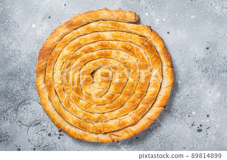 Baked homemade traditional Greek cheese pie on kitchen table. Gray background. Top view 89814899