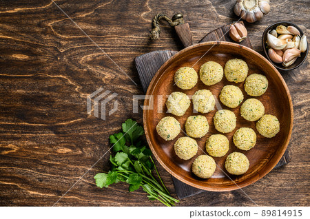 Fresh Raw falafel balls in a wooden plate. Wooden background. Top view. Copy space Fresh Raw falafel balls in a wooden plate. Wooden background. Top view. Copy space 89814915