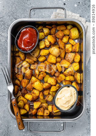 Patatas bravas traditional Spanish potatoes snack tapas in a steel tray. Gray background. Top view Patatas bravas traditional Spanish potatoes snack tapas in a steel tray. Gray background. Top view 89814916