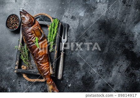 Hot smoked pike perch or zander fish in a wooden tray. Black background. Top view. Copy space Hot smoked pike perch or zander fish in a wooden tray. Black background. Top view. Copy space 89814917
