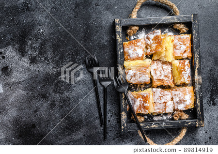 Sliced Bougatsa pie pastry with semolina custard cream. Black background. Top view. Copy space 89814919
