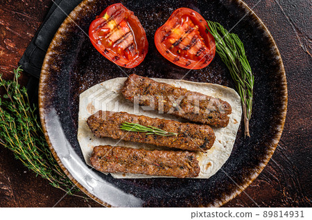 Grilled Urfa shish kebab on a plate with tomato. Dark background. top view 89814931