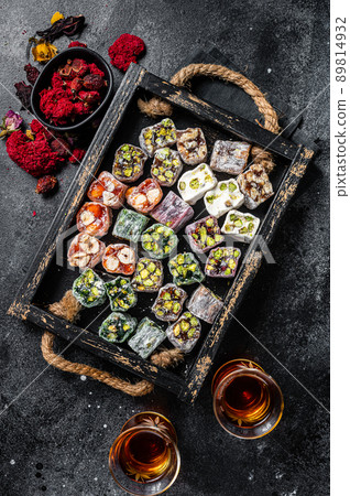 Turkish Delight Lukum, Oriental sweets with nuts and black tea. Black background. Top view 89814932