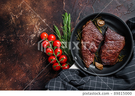 Grilled denver beef meat steak in a pan with rosemary. Dark background. Top view. Copy space Grilled denver beef meat steak in a pan with rosemary. Dark background. Top view. Copy space 89815000