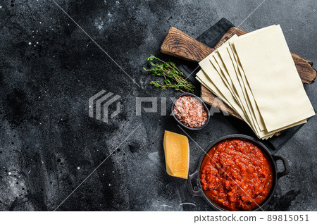 Raw Different ingredients for cooking Italian lasagna on a kitchen table. Black background. Top view. Copy space Raw Different ingredients for cooking Italian lasagna on a kitchen table. Black background. Top view. Copy space 89815051
