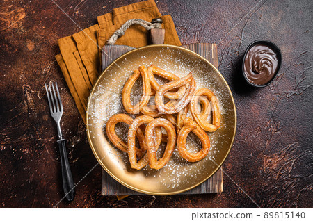 Spanish dessert churros with hot spicy chocolate. Dark background. Top view Spanish dessert churros with hot spicy chocolate. Dark background. Top view 89815140