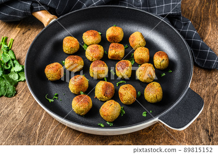 Fried Vegetarian falafel balls from spiced chickpeas in a pan. Wooden background. Top view Fried Vegetarian falafel balls from spiced chickpeas in a pan. Wooden background. Top view 89815152