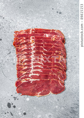 Turkish bacon Pastrami beef meat. Gray background. Top view Turkish bacon Pastrami beef meat. Gray background. Top view 89815153
