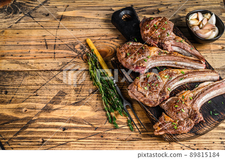 Grilled lamb mutton meat chops steaks on a cutting board. wooden background. Top view. Copy space 89815184
