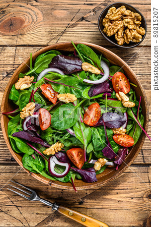 Fresh vegetable green salad with leaves mangold, swiss chard, spinach, arugula and nuts. wooden background. Top view Fresh vegetable green salad with leaves mangold, swiss chard, spinach, arugula and nuts. wooden background. Top view 89815207