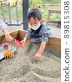 Girl wearing a mask and playing in the sandbox 89815308