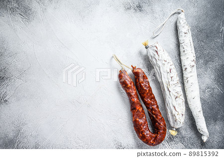 Spanish salami, fuet and chorizo sausages on a kitchen table. White background. Top view. Copy space 89815392