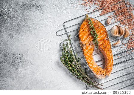 BBQ grilled Salmon Fish Steak on a grill with thyme and pink salt. White background. Top view. Copy space 89815393