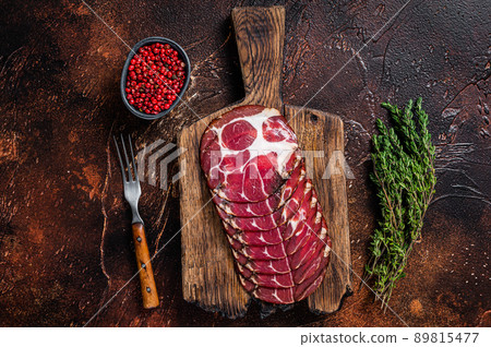 Sliced cured coppa ham on wooden board with thyme. Dark background. Top view Sliced cured coppa ham on wooden board with thyme. Dark background. Top view 89815477