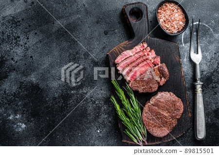 Fillet Mignon tenderloin Grilled and sliced meat beef steaks. Black background. Top view. Copy space 89815501