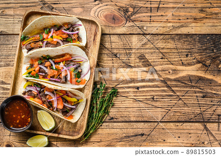 Tacos with beef meat, onion, tomato, sweet pepper and salsa. Mexican food. wooden background. Top view. Copy space 89815503