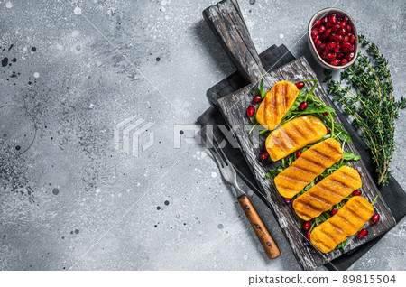 BBQ Grilled Halloumi cheese with arugula on wooden board. Gray background. Top view. Copy space 89815504