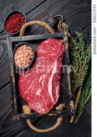 Unccoked rump steak or raw top sirloin beef meat steak. Black wooden background. Top view 89815545