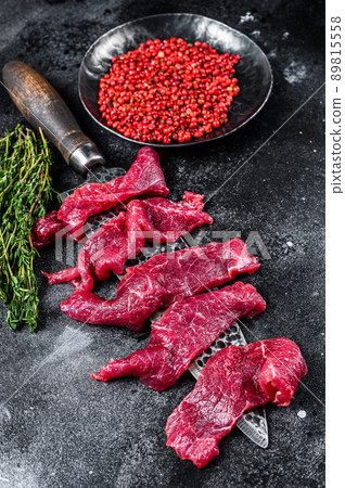 Fresh beef marbled meat cut into thin strips for goulash. Black background. Top view 89815558