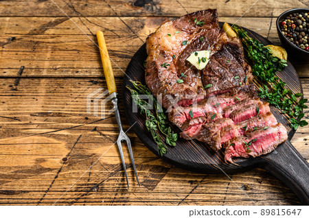 Roast rib eye beef meat steak on a cutting board. wooden background. Top view. Copy space Roast rib eye beef meat steak on a cutting board. wooden background. Top view. Copy space 89815647