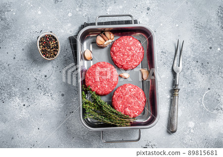 Fresh Raw Ground mince beef meat Hamburger steak patty in a steel tray. Gray background. Top view 89815681