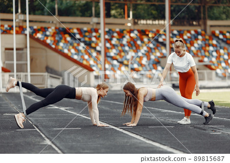 Beautiful girls at the stadium. Sports girls in a sportswear. People use a eraser. Beautiful girls at the stadium. Sports girls in a sportswear. People use a eraser. 89815687