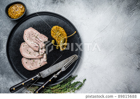 Veal or beef boiled tongue slices on a plate. White background. Top view. Copy space Veal or beef boiled tongue slices on a plate. White background. Top view. Copy space 89815688