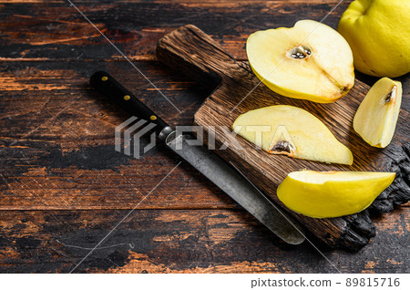 Fresh gold quince fruits on a cutting board. Dark wooden background. Top view. Copy space Fresh gold quince fruits on a cutting board. Dark wooden background. Top view. Copy space 89815716