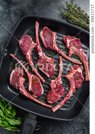 Ready for cooking Raw lamb, mutton chops steaks in a pan with herbs. Black background. Top view Ready for cooking Raw lamb, mutton chops steaks in a pan with herbs. Black background. Top view 89815717