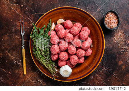 Raw meatballs from mince lamb mutton meat with thyme on rustic plate. Dark background. Top view 89815742
